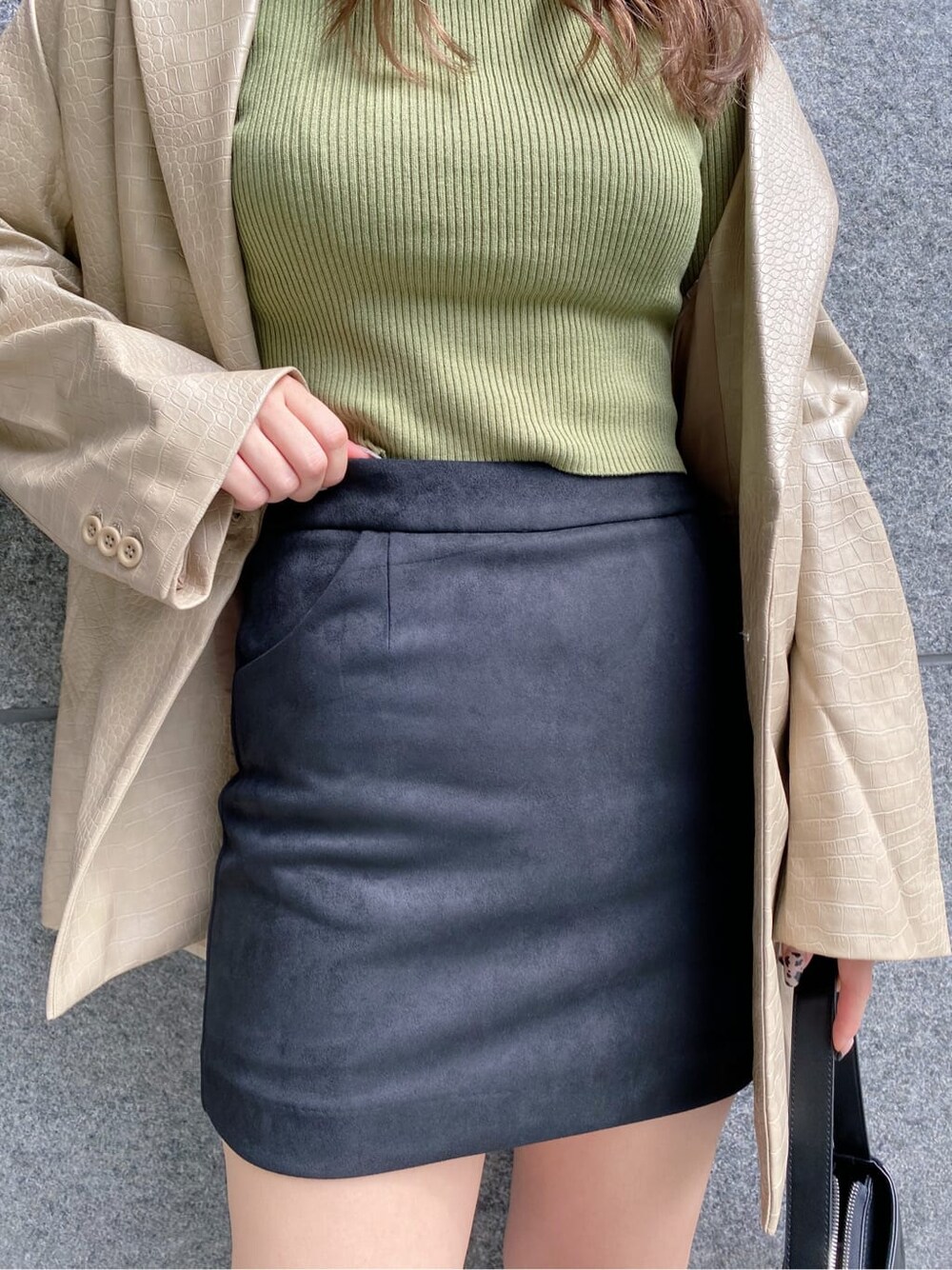 ブラック系のスカート、ブラック系のショルダーバッグ、ベージュ系のニット/セーターを着用したレディースの秋コーディネートの6枚目の写真