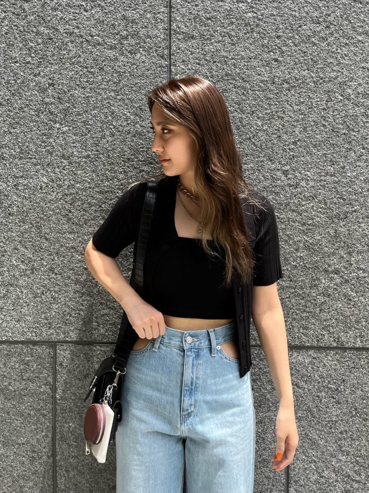 ブラック系のショルダーバッグ、ブルー系のデニムパンツ、ブラック系のニット/セーターを着用したレディースの夏コーディネートの3枚目の写真