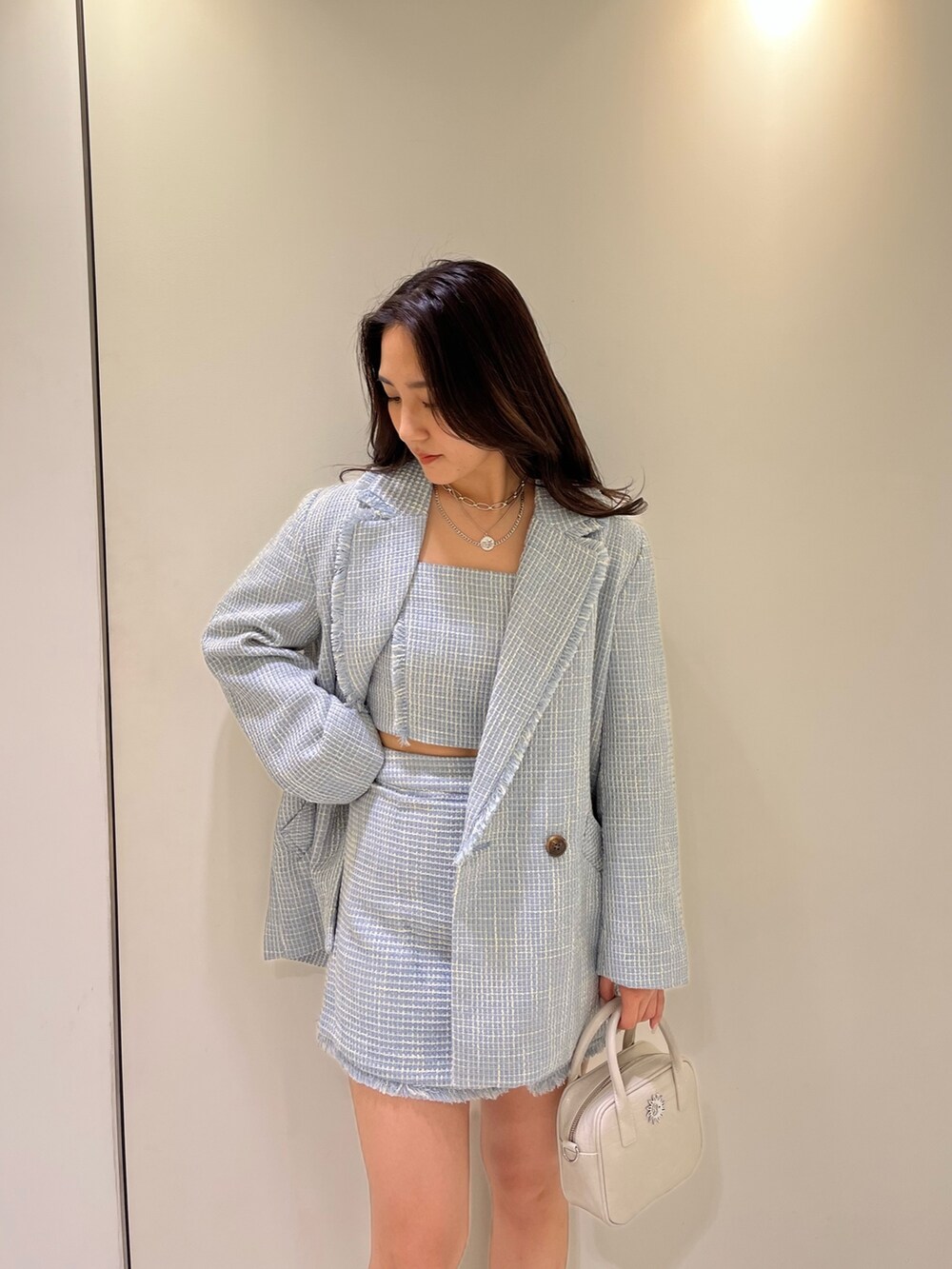 ブルー系のテーラードジャケット、ブルー系のキャミソール、ブルー系のスカートを着用したレディースの冬コーディネートの3枚目の写真