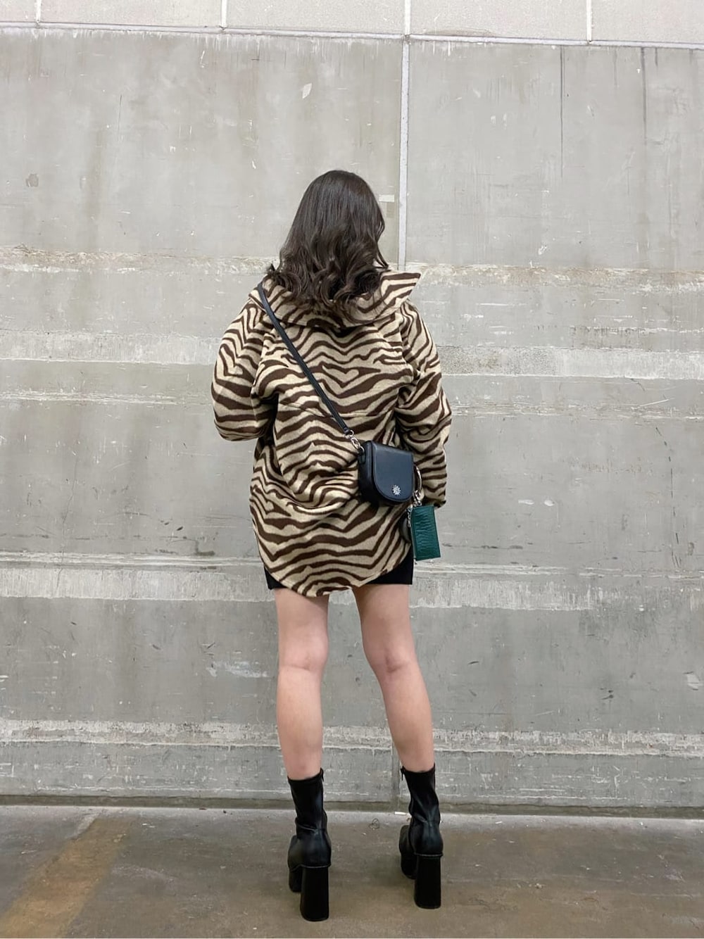 ブラック系のワンピース、ブラック系のショルダーバッグ、ブラック系のブーツを着用したレディースの秋コーディネートの2枚目の写真