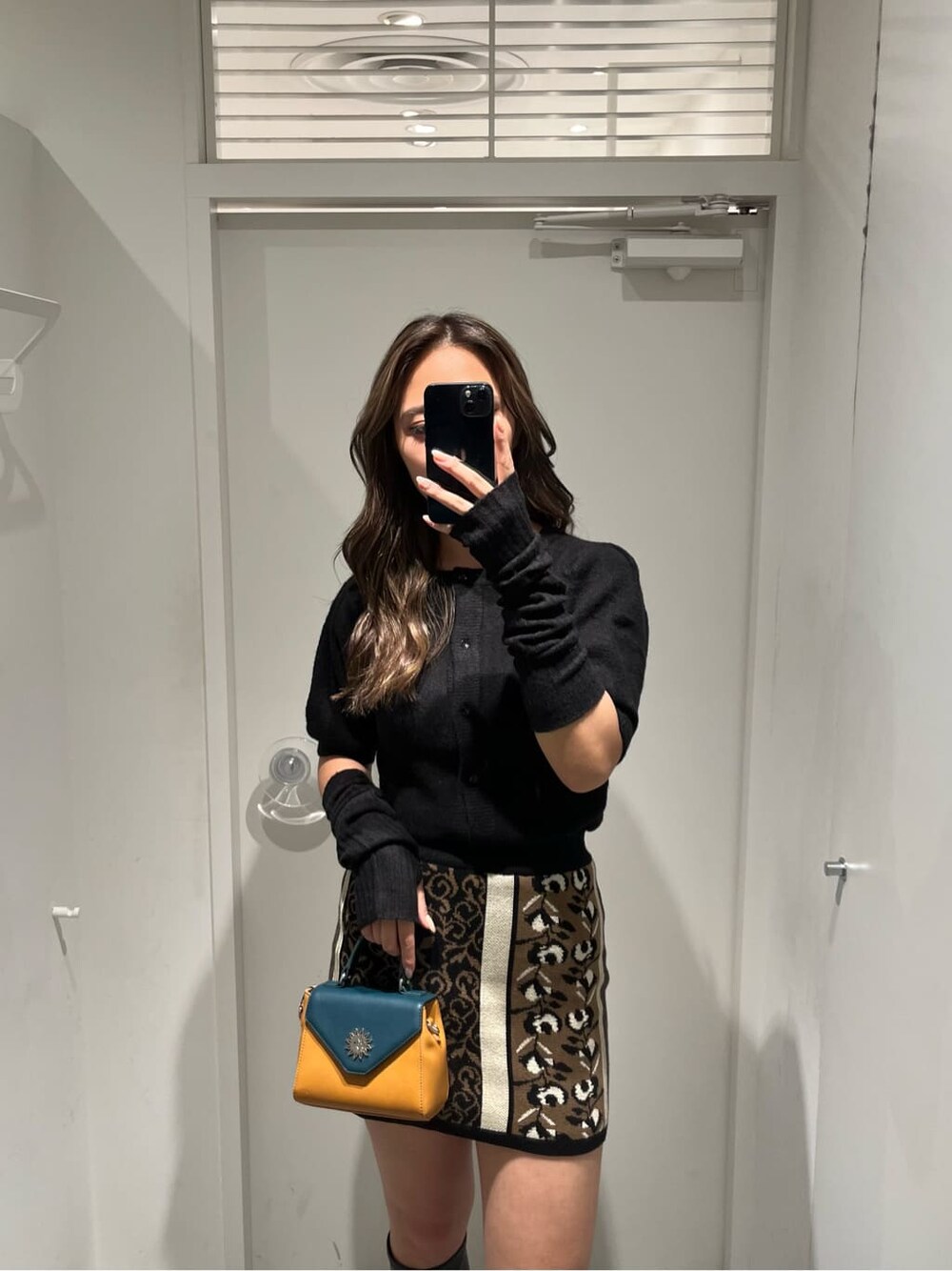 ブラック系のスカート、ブラック系のブーツ、ブラック系のニット/セーターを着用したレディースの秋コーディネートの3枚目の写真