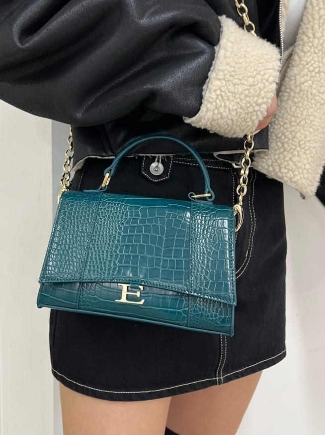 ブラック系のデニムスカート、ブラック系のブルゾン、ブラック系のブーツを着用したレディースの秋コーディネートの9枚目の写真