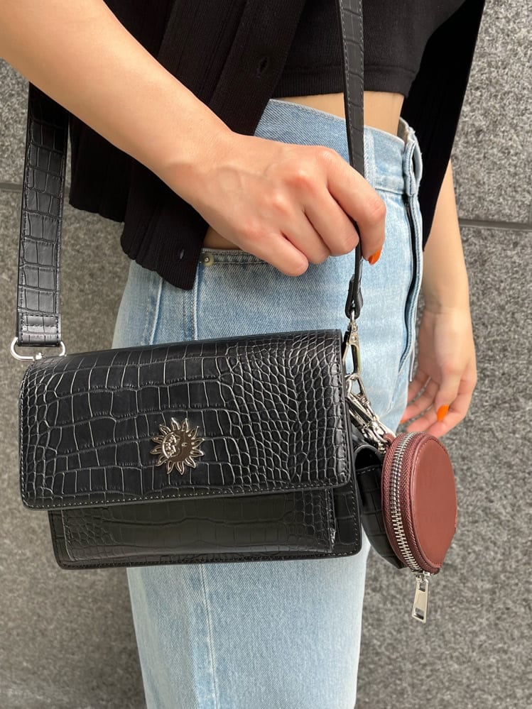 ブラック系のショルダーバッグ、ブルー系のデニムパンツ、ブラック系のニット/セーターを着用したレディースの夏コーディネートの9枚目の写真