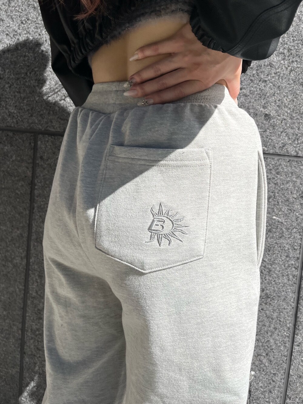 ブラック系のブルゾン、グレー系のスウェットパンツ、シルバー系のボディバッグ/ウエストポーチを着用したレディースの冬コーディネートの5枚目の写真