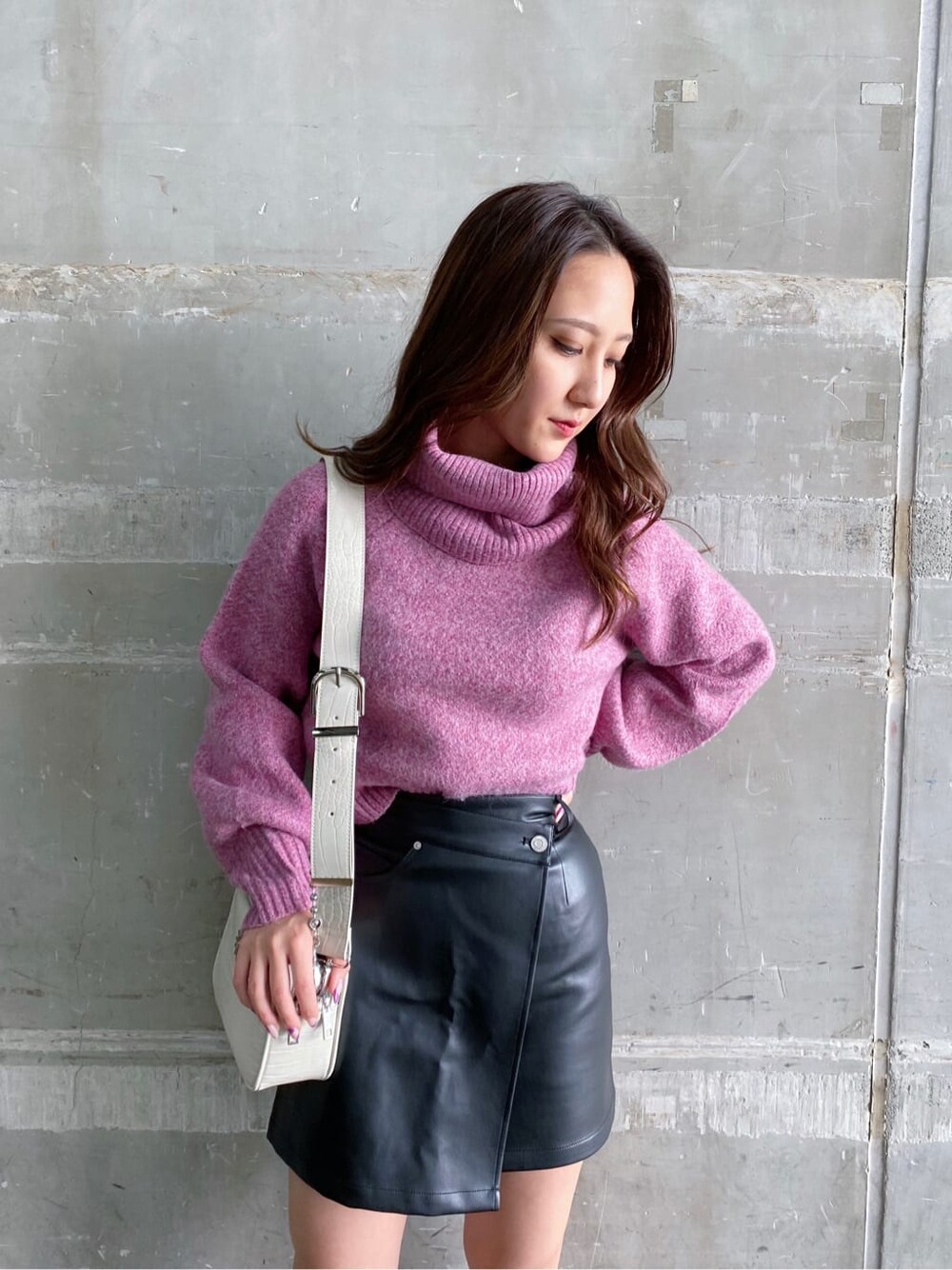 ブラック系のブーツ、ピンク系のニット/セーター、ホワイト系のショルダーバッグを着用したレディースの秋コーディネートの3枚目の写真