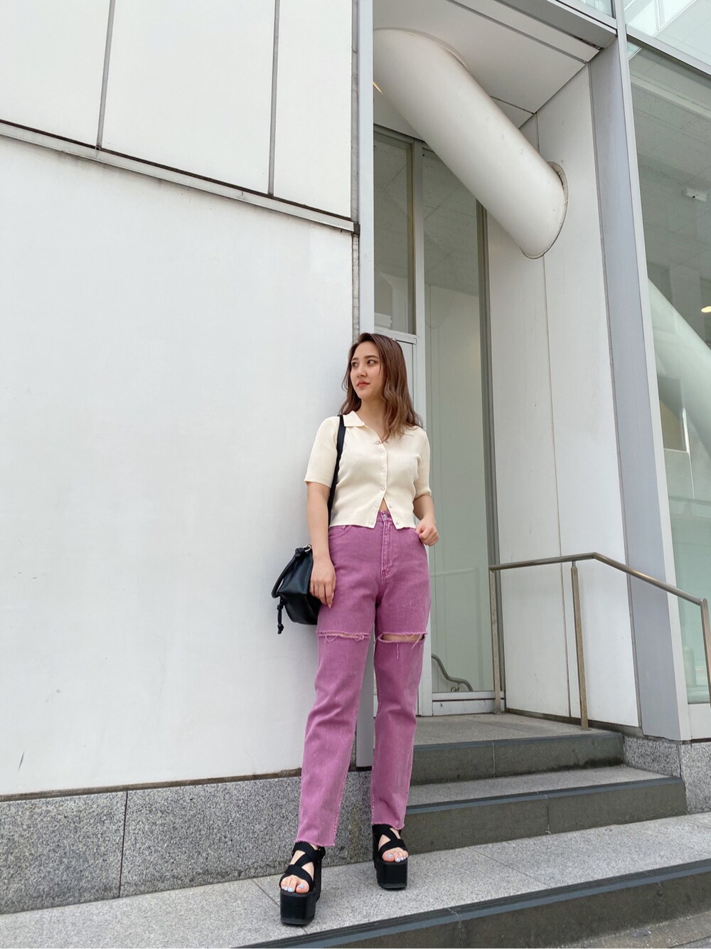 ブラック系のショルダーバッグ、ブラック系のサンダル、ホワイト系のTシャツ/カットソーを着用したレディースの春コーディネートの2枚目の写真