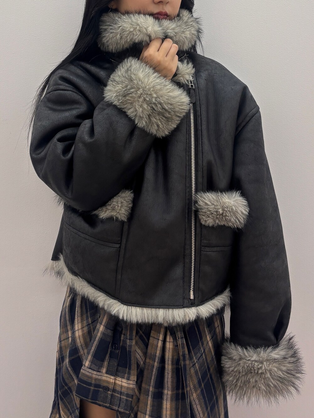 ブラック系のブルゾン、ブラック系のニット/セーター、ブルー系のスカートを着用したレディースの秋コーディネートの5枚目の写真