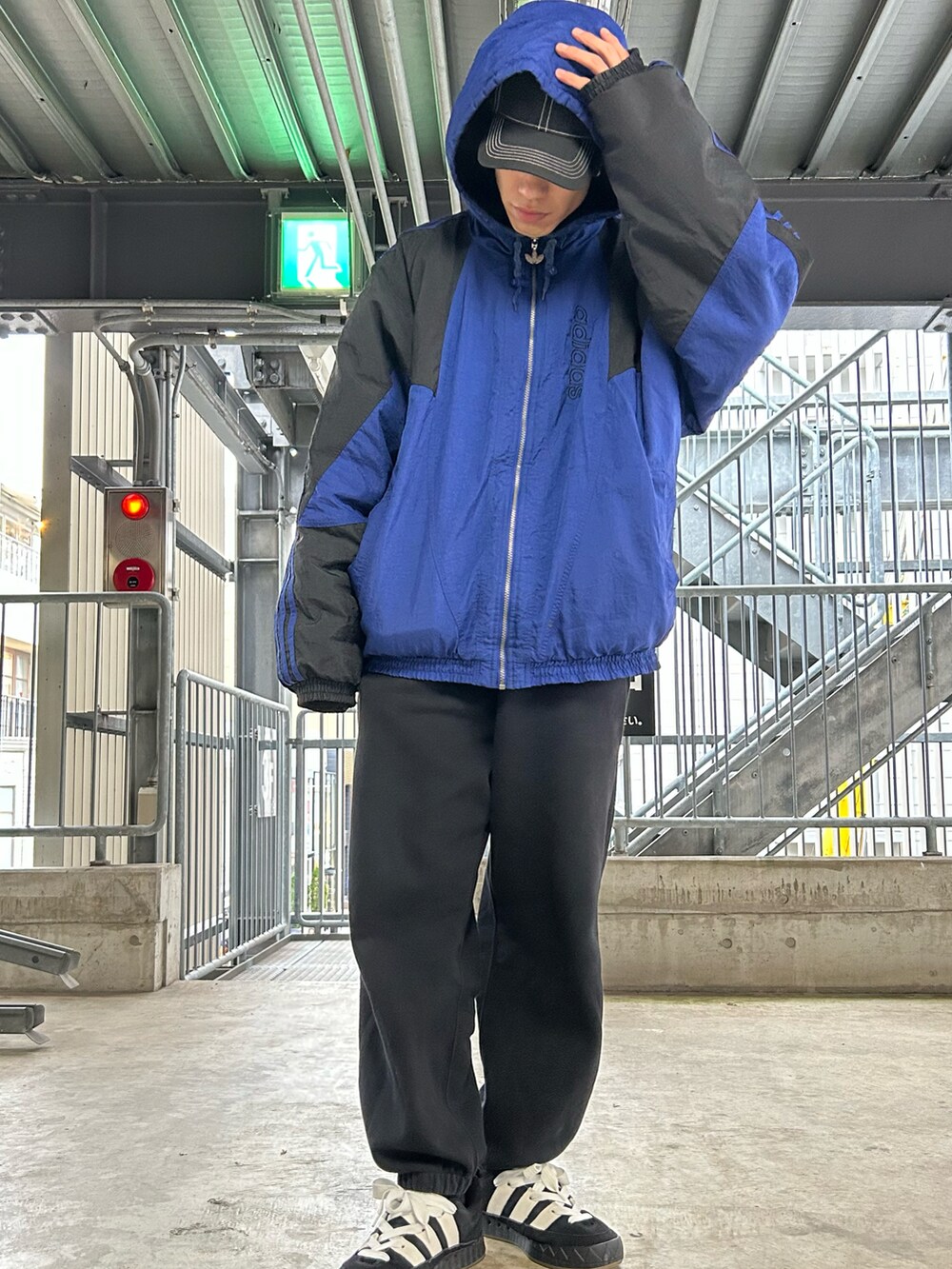 ブラック系のスニーカー、ブラック系のスウェットパンツ、ブルー系のダウンジャケット/コートを着用したメンズの冬コーディネートの2枚目の写真