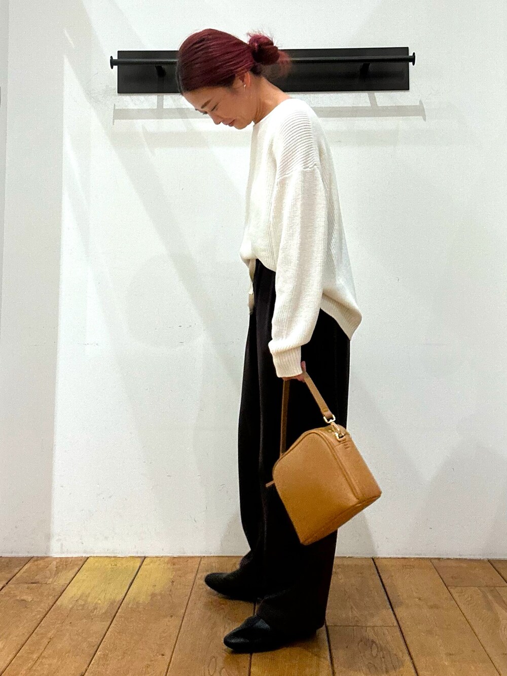 ホワイト系のニット/セーター、ブラウン系のその他パンツ、ベージュ系のショルダーバッグを着用したレディースの冬コーディネートの3枚目の写真