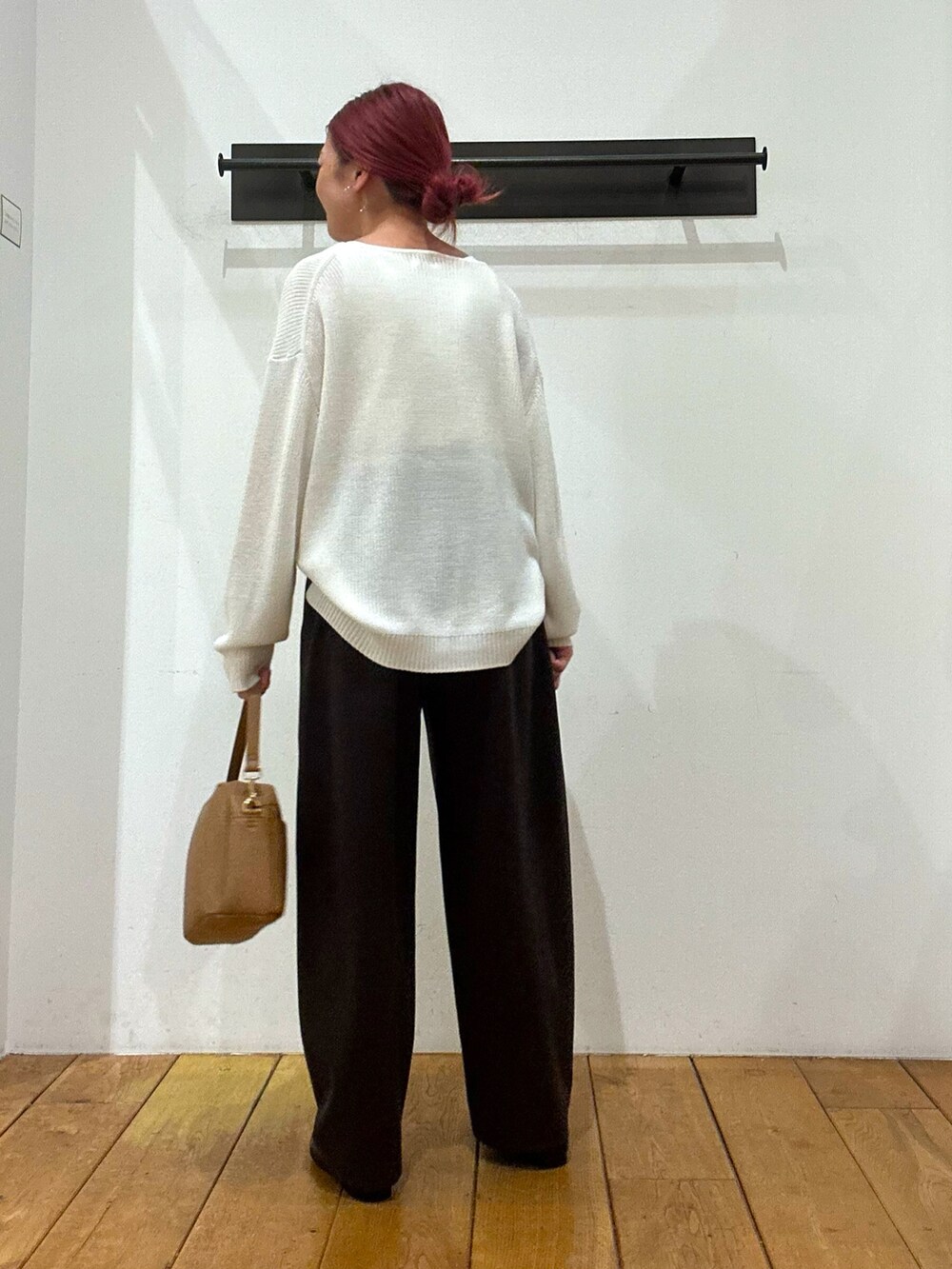 ホワイト系のニット/セーター、ブラウン系のその他パンツ、ベージュ系のショルダーバッグを着用したレディースの冬コーディネートの2枚目の写真