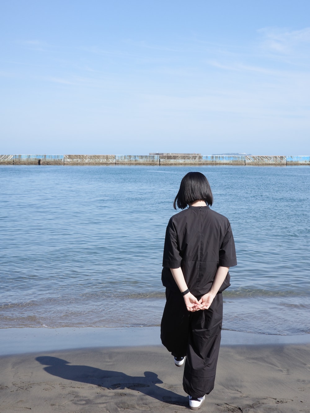 ブラック系のシャツ/ブラウス、ブラック系のその他パンツ、ホワイト系のスニーカーを着用したレディースの春コーディネートの3枚目の写真