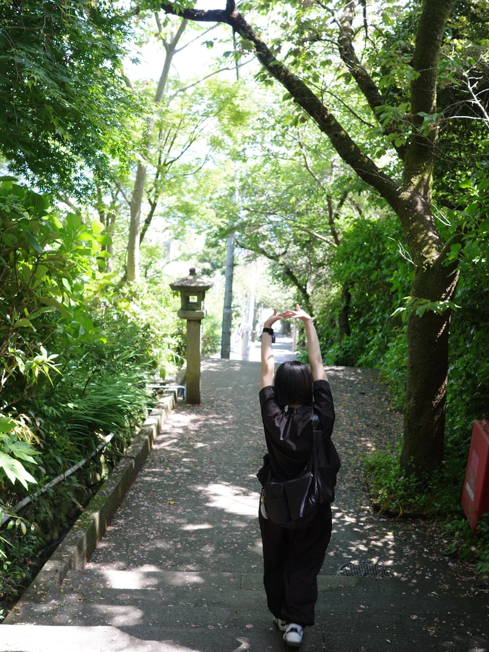 ブラック系のシャツ/ブラウス、ブラック系のその他パンツ、ホワイト系のスニーカーを着用したレディースの春コーディネートの5枚目の写真