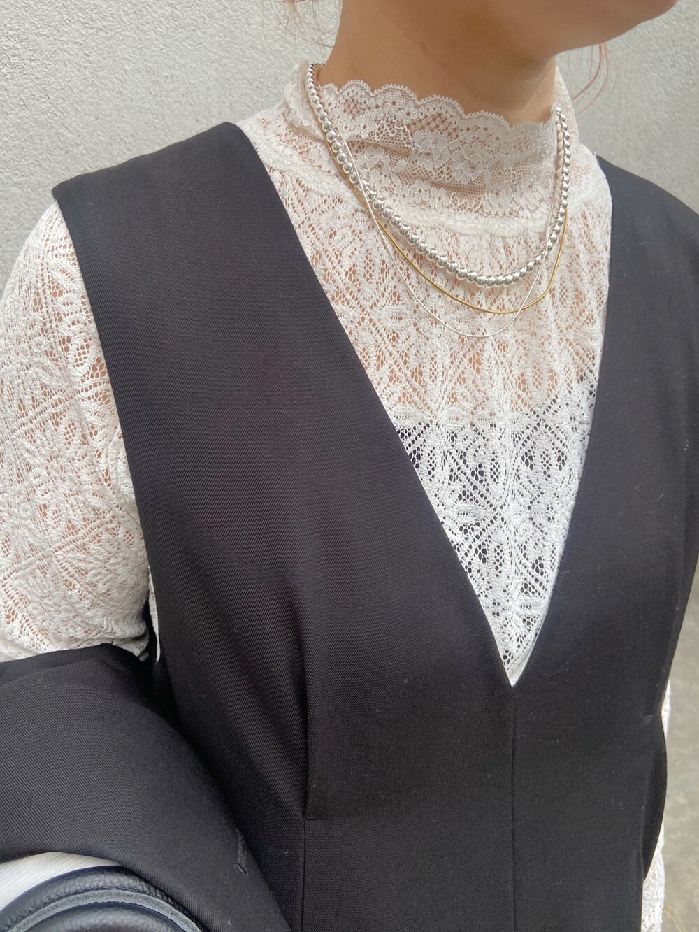 ブラック系のボストンバッグ、ブラック系のサロペット/オーバーオール、ホワイト系のTシャツ/カットソーを着用したレディースの冬コーディネートの2枚目の写真