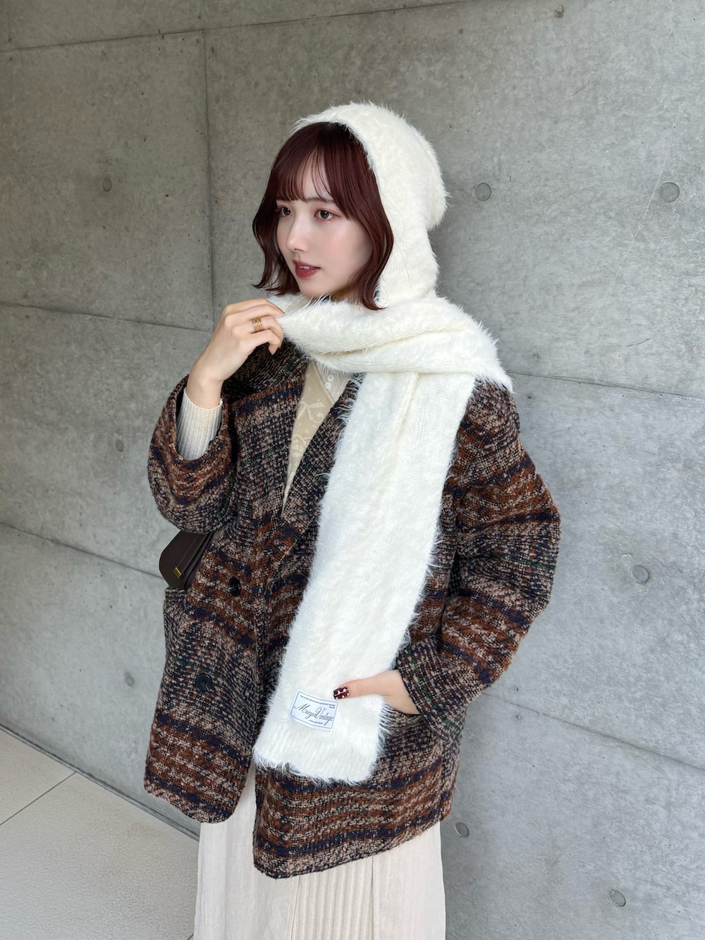 ブラウン系のその他アウター、ホワイト系のニット/セーター、ベージュ系のベストを着用したレディースの冬コーディネートの2枚目の写真