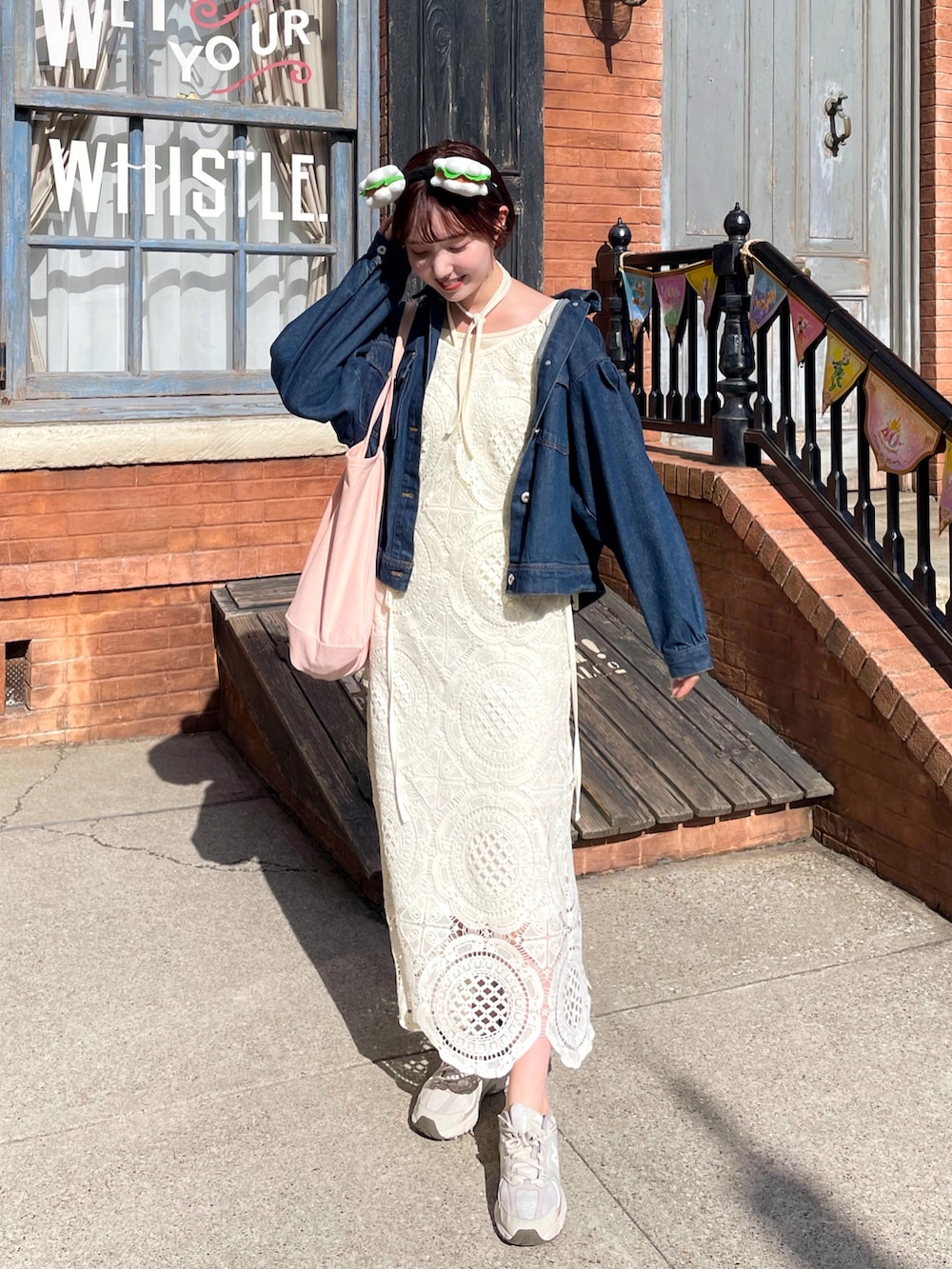 ブルー系のデニムジャケット、ホワイト系のワンピース、ホワイト系のキャミソールを着用したレディースの春コーディネートの2枚目の写真
