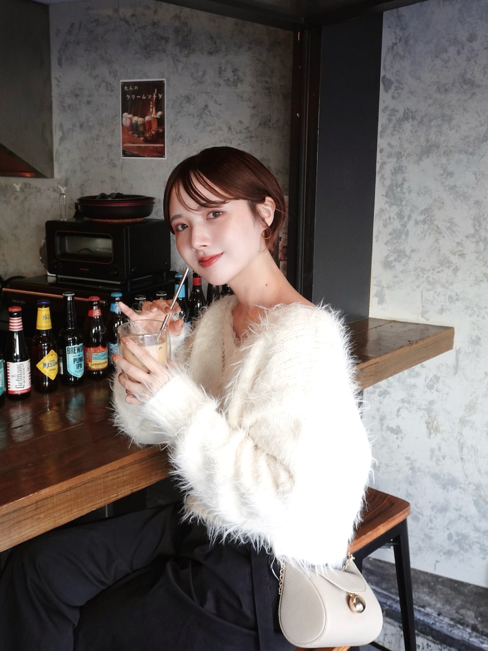 ホワイト系のニット/セーター、ブラック系のその他パンツ、ホワイト系のショルダーバッグを着用したレディースの冬コーディネートの2枚目の写真