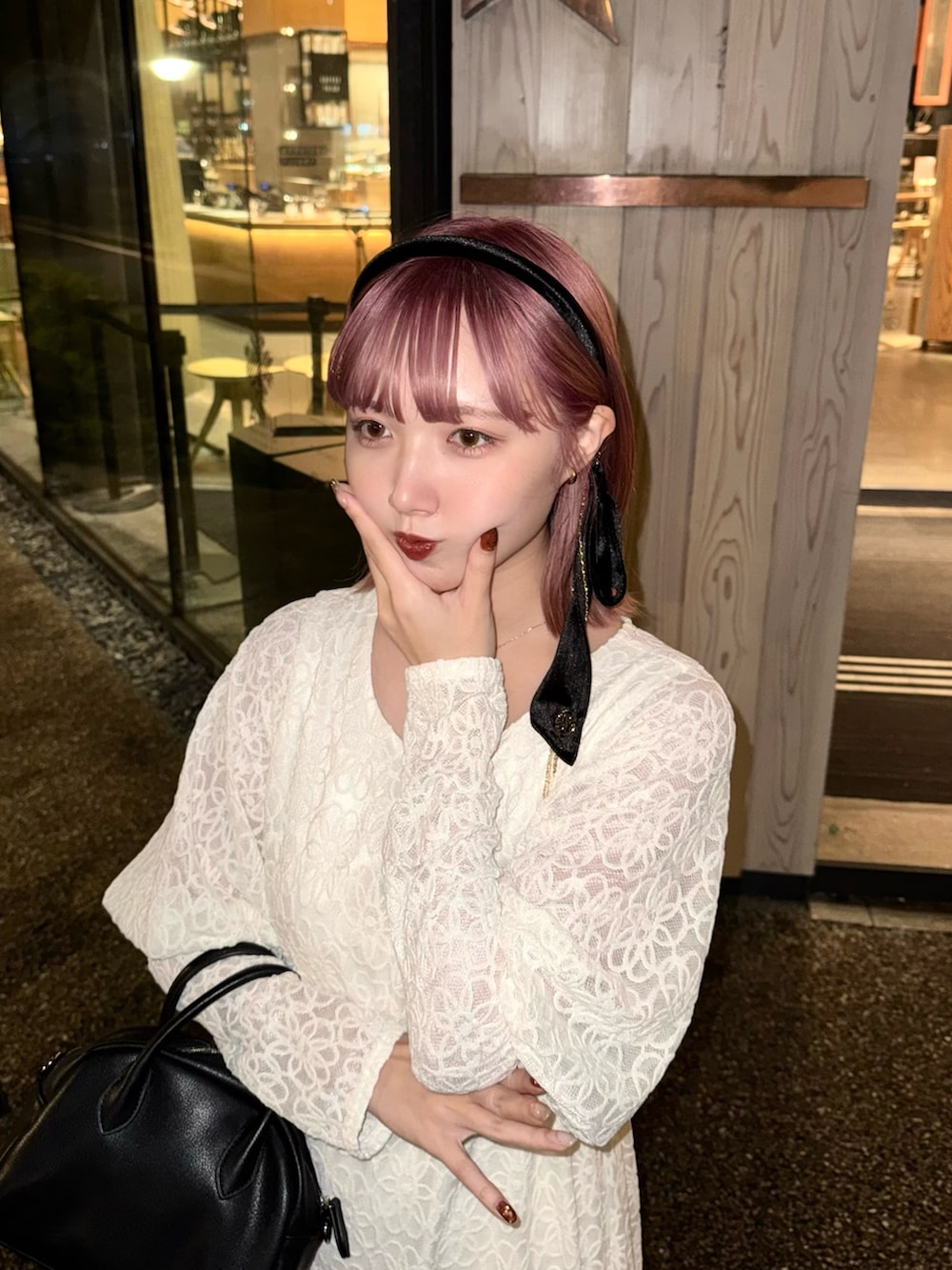 ホワイト系のワンピース、ブラック系のボストンバッグ、ブラック系のパンプスを着用したレディースの春コーディネートの2枚目の写真