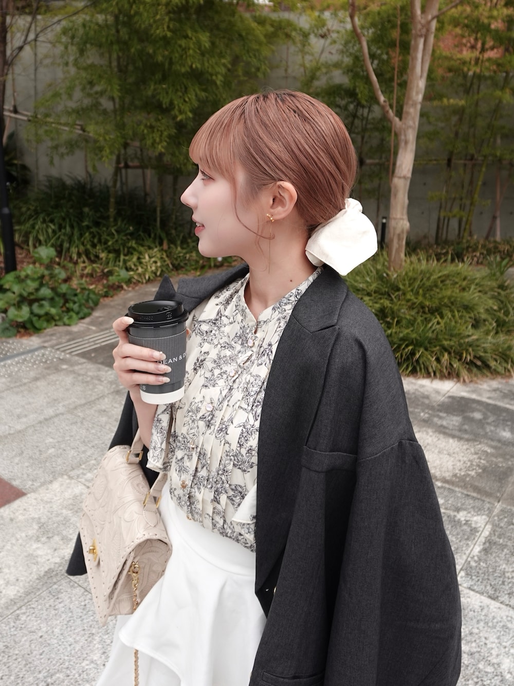 グレー系のテーラードジャケット、ホワイト系のシャツ/ブラウス、ベージュ系のショルダーバッグを着用したレディースの春コーディネートの2枚目の写真