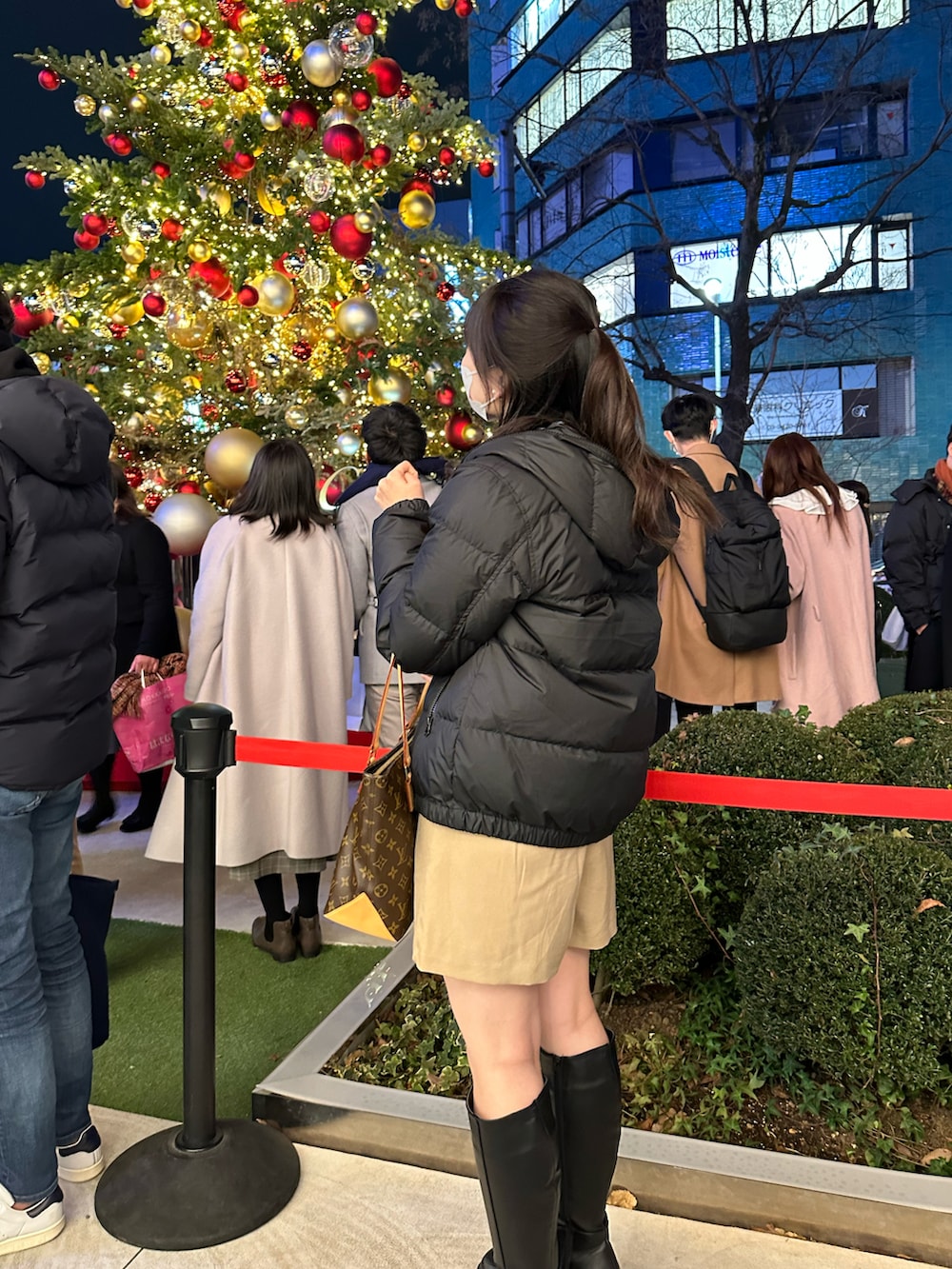 ブラック系のダウンジャケット/コート、ベージュ系のチノパンツ、ブラック系のブーツを着用したレディースの冬コーディネートの2枚目の写真