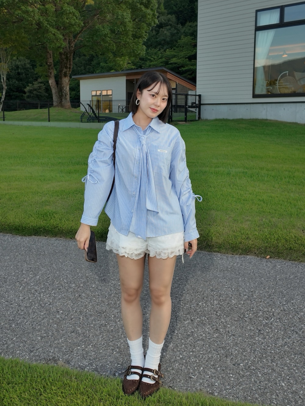 ブルー系のシャツ/ブラウス、ホワイト系のパンツ、ブラウン系のバッグを着用したレディースの秋コーディネートの4枚目の写真