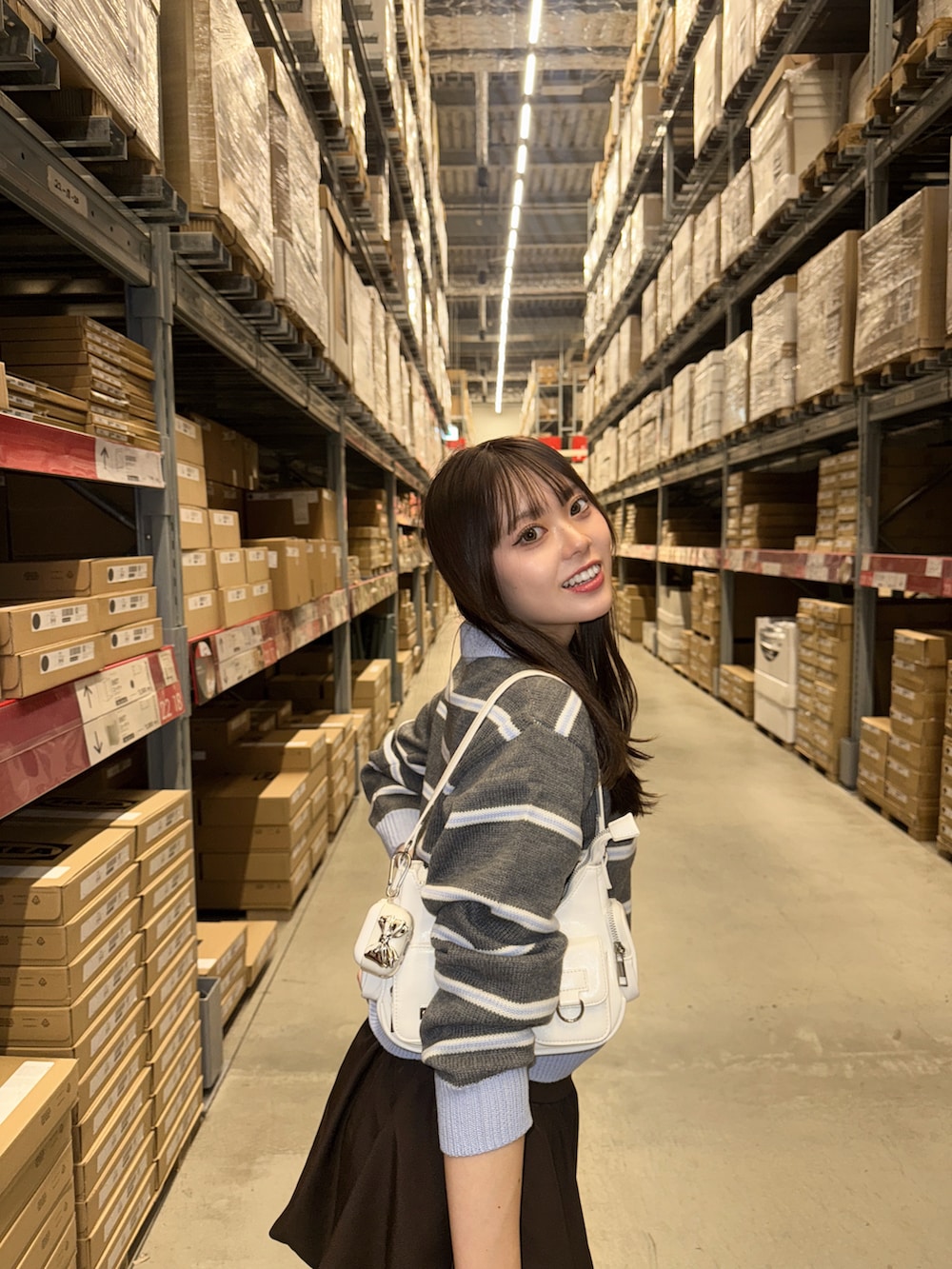 ブラウン系のスカート、グレー系のトップス、ブラック系のローファーを着用したレディースの秋コーディネートの4枚目の写真