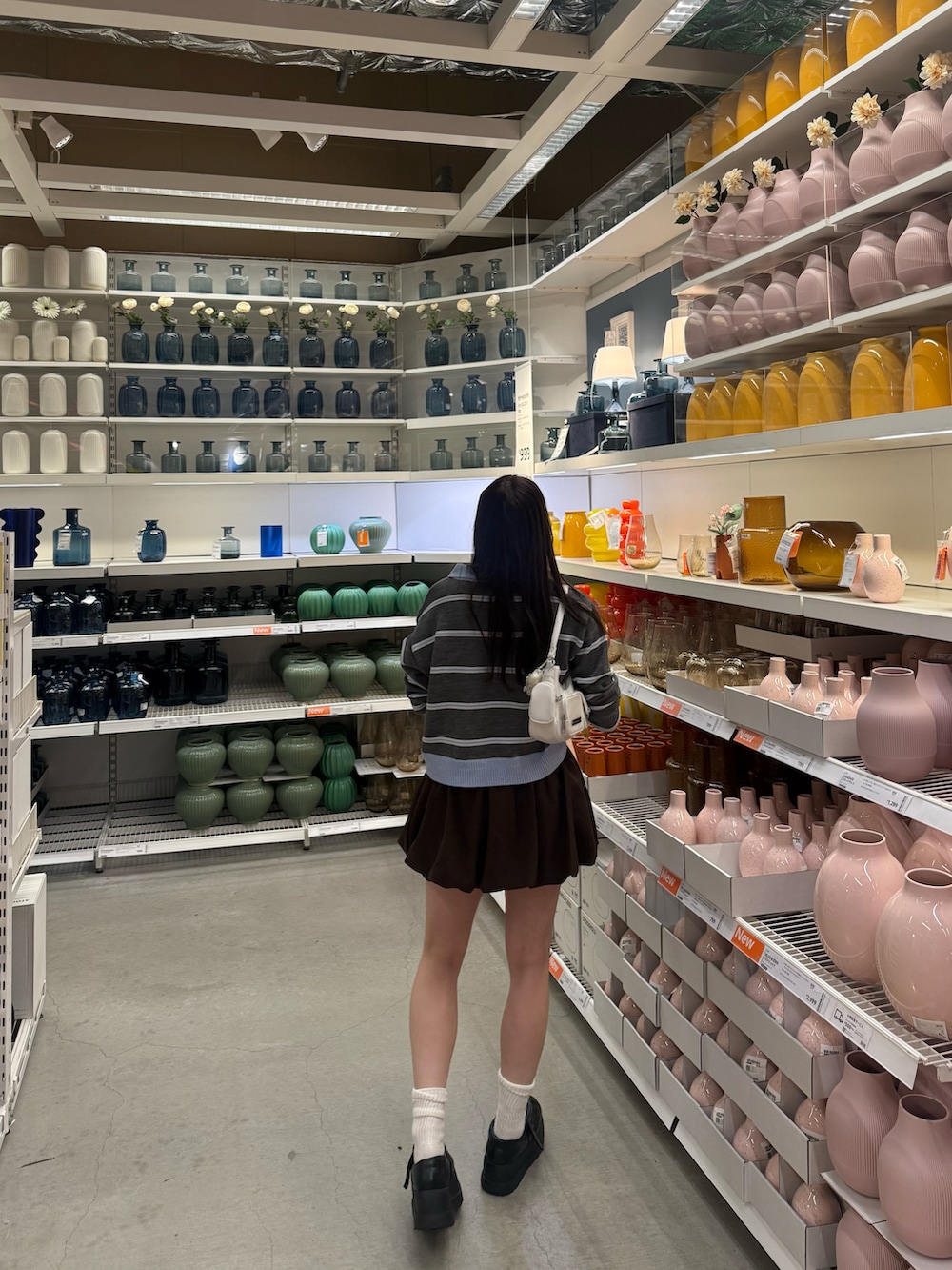 ブラウン系のスカート、グレー系のトップス、ブラック系のローファーを着用したレディースの秋コーディネートの2枚目の写真