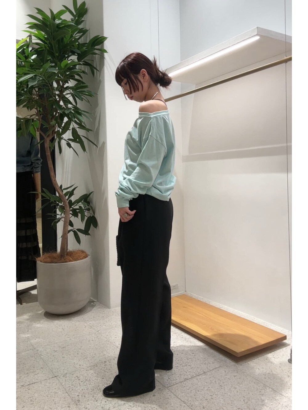 グリーン系のTシャツ/カットソー、ブラック系のスラックス、シルバー系のチョーカーを着用したレディースの春コーディネートの4枚目の写真