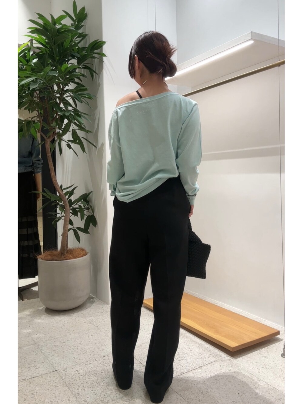 グリーン系のTシャツ/カットソー、ブラック系のスラックス、シルバー系のチョーカーを着用したレディースの春コーディネートの3枚目の写真