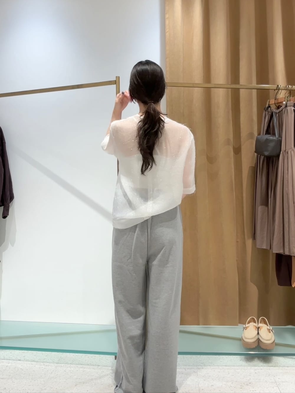 ホワイト系のシャツ/ブラウス、グレー系のスウェットパンツ、ゴールド系のパンプスを着用したレディースの夏コーディネートの3枚目の写真