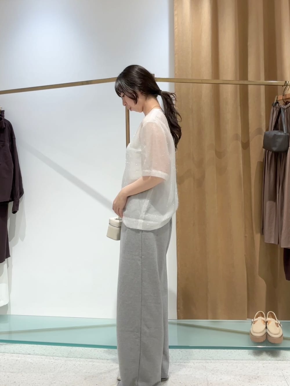 ホワイト系のシャツ/ブラウス、グレー系のスウェットパンツ、ゴールド系のパンプスを着用したレディースの夏コーディネートの4枚目の写真