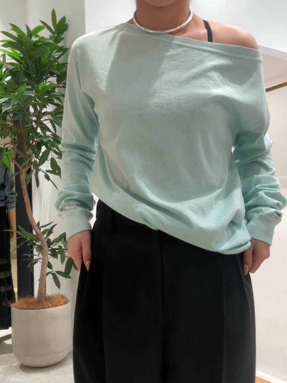 グリーン系のTシャツ/カットソー、ブラック系のスラックス、シルバー系のチョーカーを着用したレディースの春コーディネートの5枚目の写真