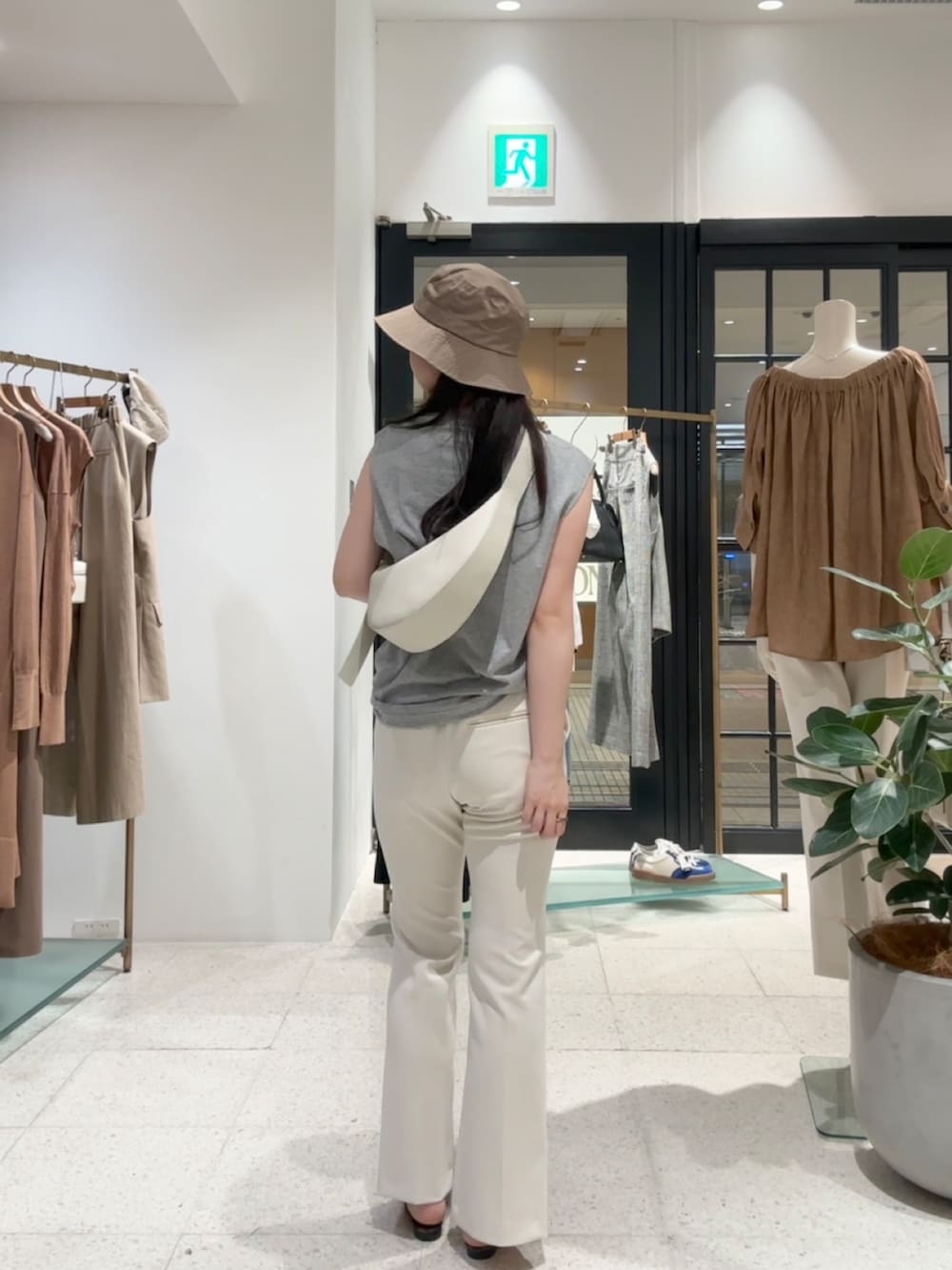 グレー系のTシャツ/カットソー、ホワイト系のスラックス、ホワイト系のボディバッグ/ウエストポーチを着用したレディースの夏コーディネートの3枚目の写真