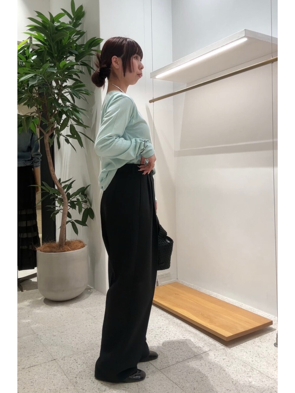 グリーン系のTシャツ/カットソー、ブラック系のスラックス、シルバー系のチョーカーを着用したレディースの春コーディネートの2枚目の写真