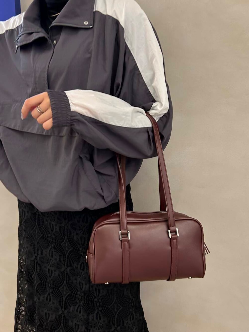 ブラック系のTシャツ/カットソー、レッド系のボストンバッグ、ブラック系のブーツを着用したレディースの秋コーディネートの3枚目の写真