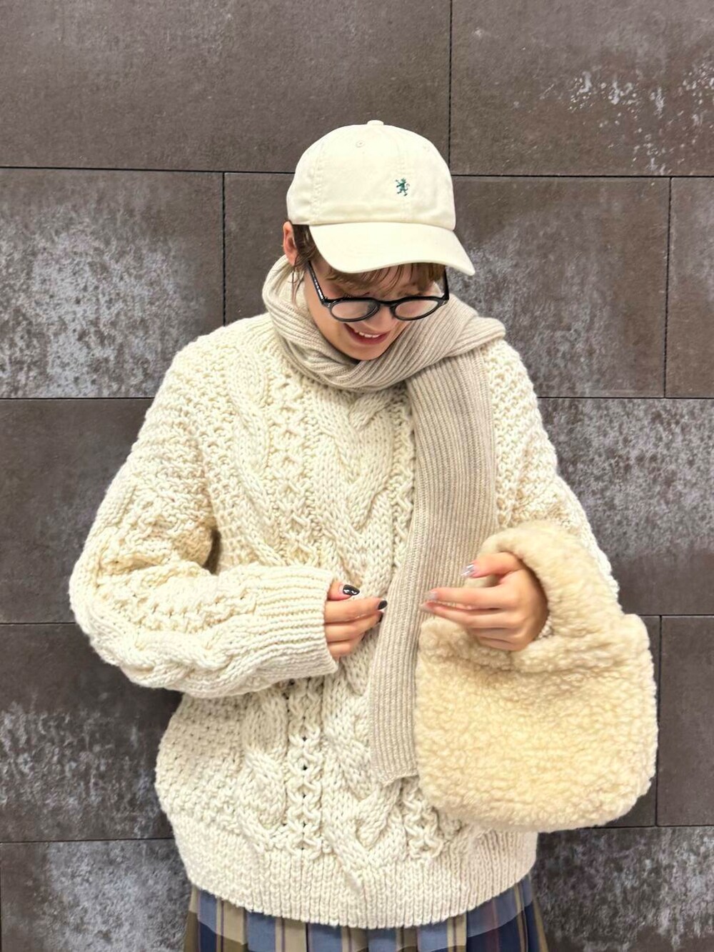 ホワイト系のニット/セーター、ブラック系のブーツ、ブルー系のスカートを着用したレディースの秋コーディネートの3枚目の写真