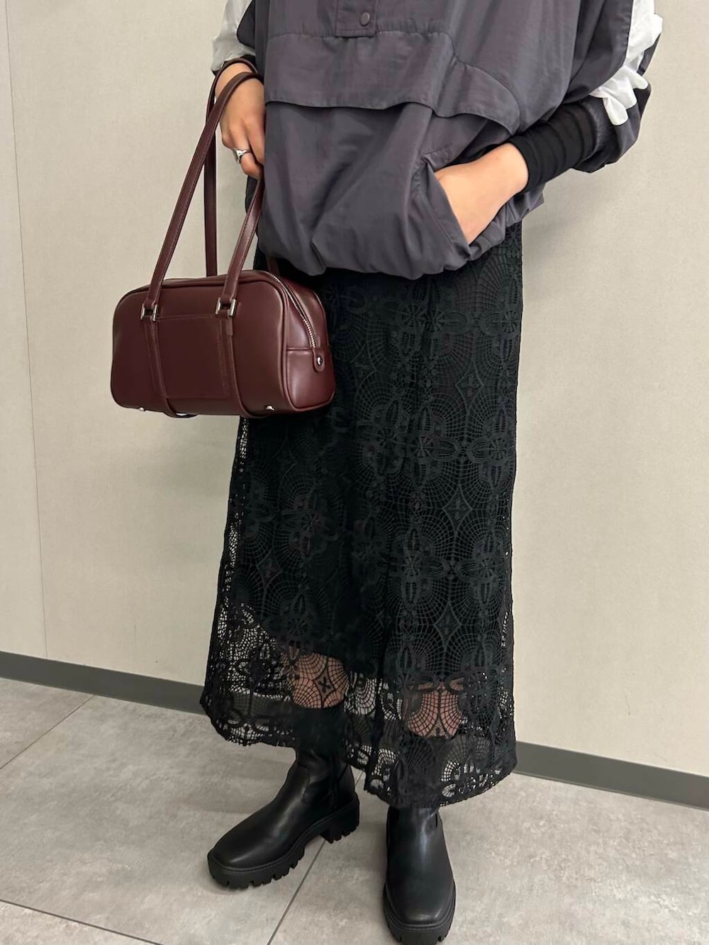 ブラック系のTシャツ/カットソー、レッド系のボストンバッグ、ブラック系のブーツを着用したレディースの秋コーディネートの2枚目の写真