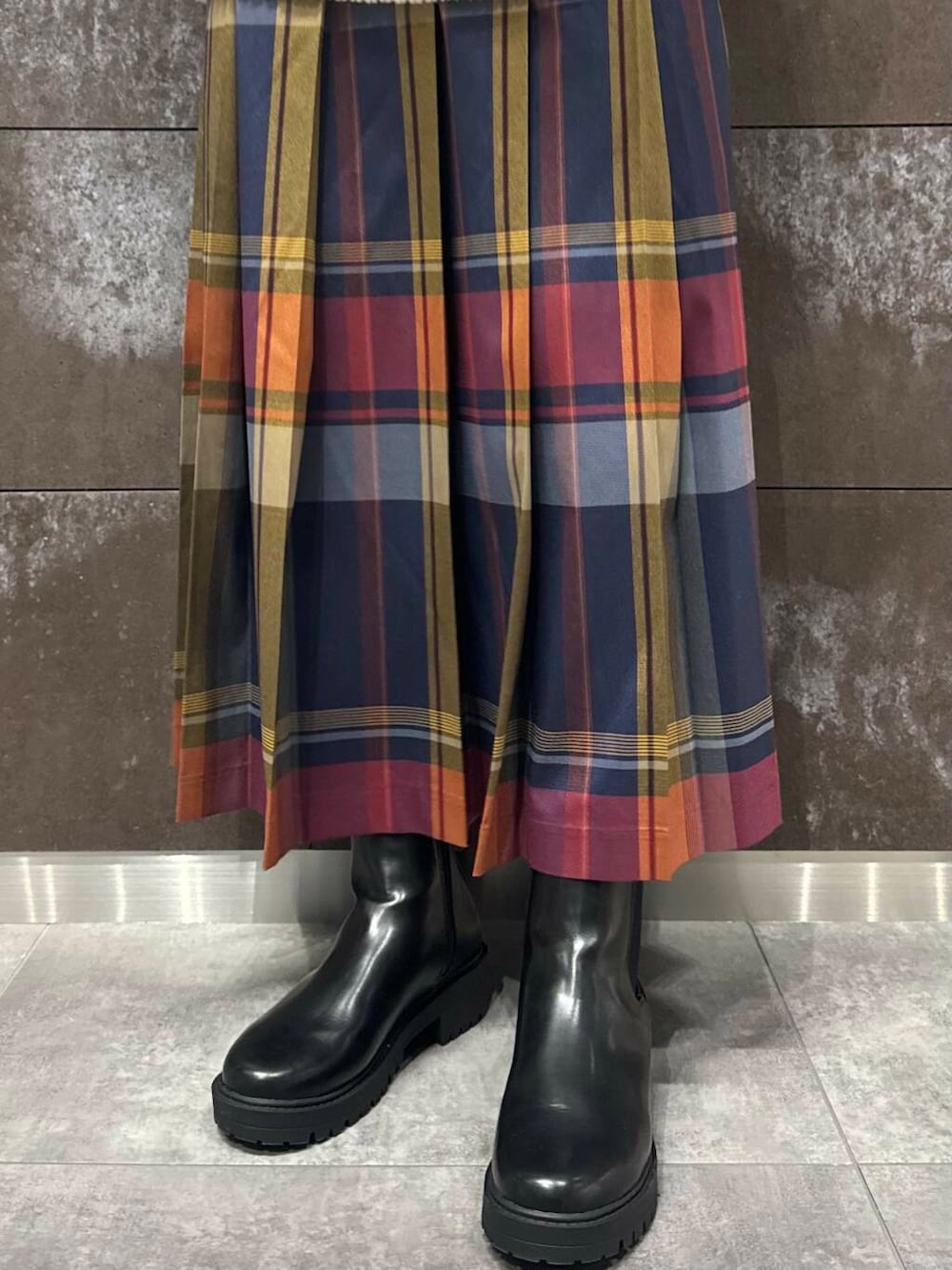 ホワイト系のニット/セーター、ブラック系のブーツ、ブルー系のスカートを着用したレディースの秋コーディネートの4枚目の写真