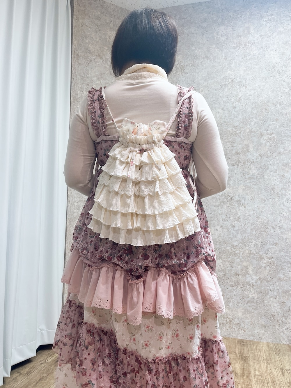 ピンク系のチュニック、ピンク系のスカート、レッド系のパンプスを着用したレディースの秋コーディネートの7枚目の写真