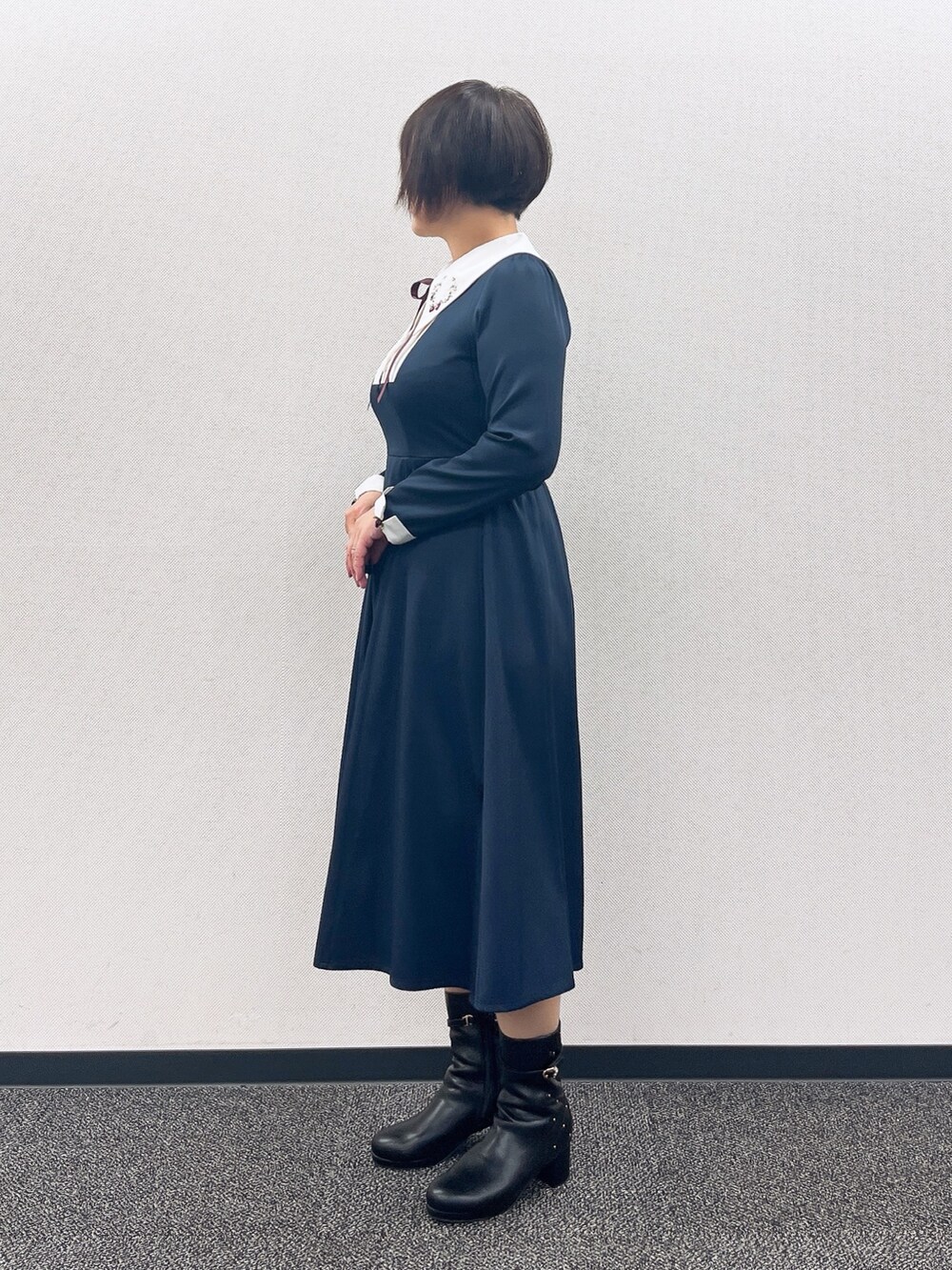 ブルー系のワンピース、レッド系のカーディガン/ボレロ、ブラック系のブーツを着用したレディースの冬コーディネートの7枚目の写真