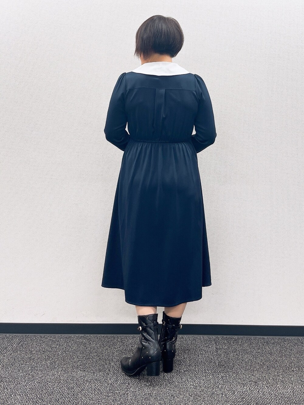 ブルー系のワンピース、レッド系のカーディガン/ボレロ、ブラック系のブーツを着用したレディースの冬コーディネートの8枚目の写真