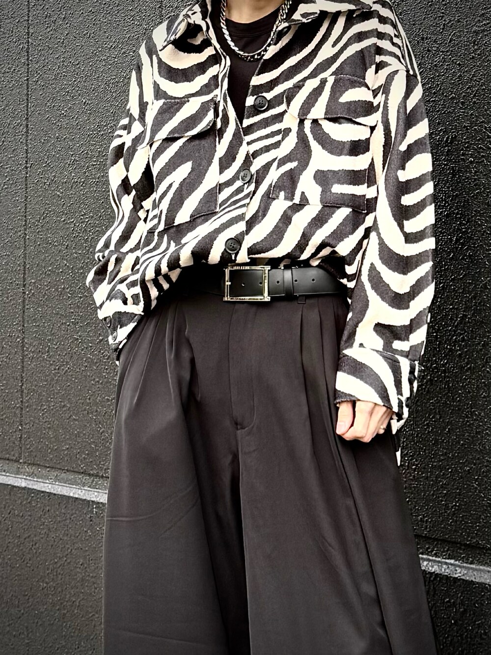 ブラック系のTシャツ/カットソー、ブラック系のシャツ/ブラウス、ホワイト系のスラックスを着用したメンズの春コーディネートの2枚目の写真