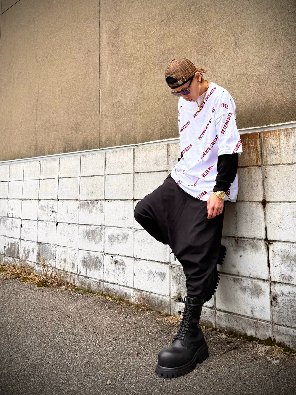 ホワイト系のTシャツ/カットソー、ブラック系のその他パンツ、ブラック系のブーツを着用したメンズの春コーディネートの2枚目の写真