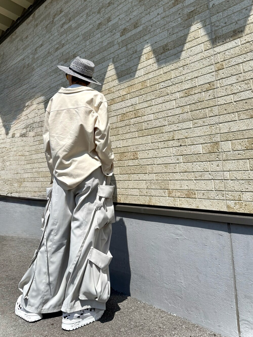 ホワイト系のTシャツ/カットソー、ホワイト系のシャツ/ブラウス、ブラック系のカーゴパンツを着用したメンズの春コーディネートの2枚目の写真