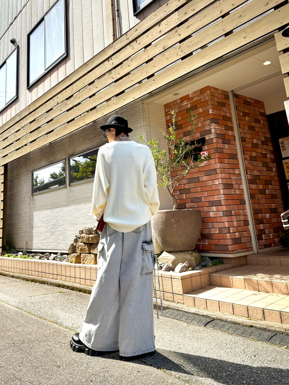 ホワイト系のTシャツ/カットソー、ホワイト系のカーゴパンツ、ブラック系のブーツを着用したメンズの春コーディネートの3枚目の写真