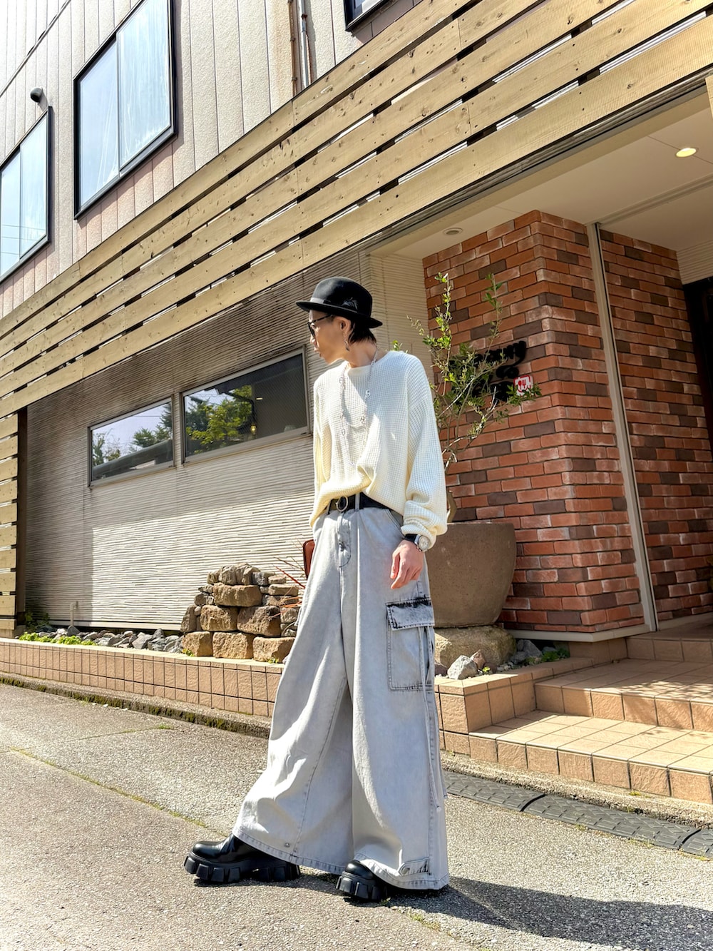 ホワイト系のTシャツ/カットソー、ホワイト系のカーゴパンツ、ブラック系のブーツを着用したメンズの春コーディネートの2枚目の写真