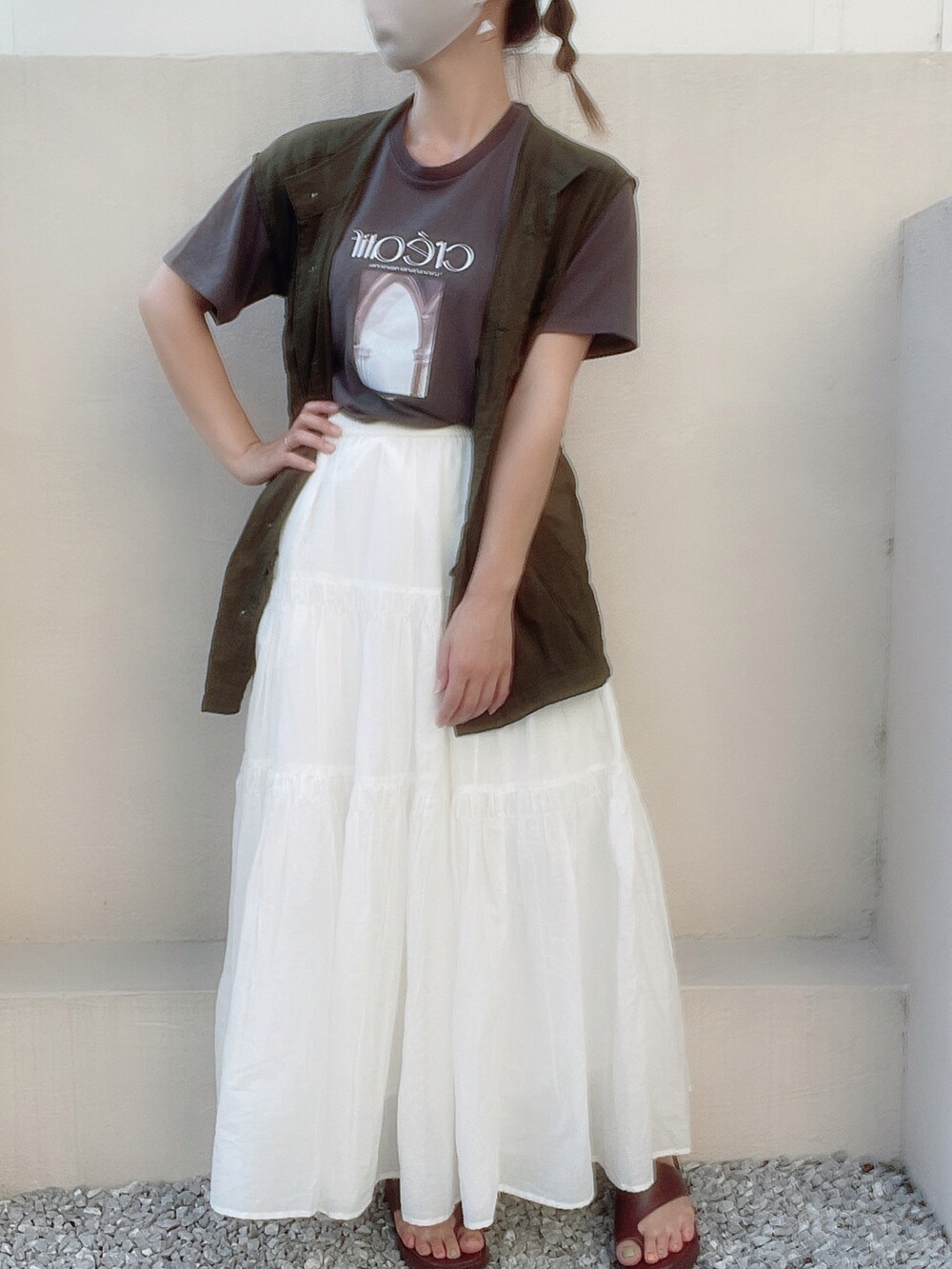 ホワイト系のハンドバッグ、グリーン系のベスト、グレー系のTシャツ/カットソーを着用したレディースの夏コーディネートの2枚目の写真