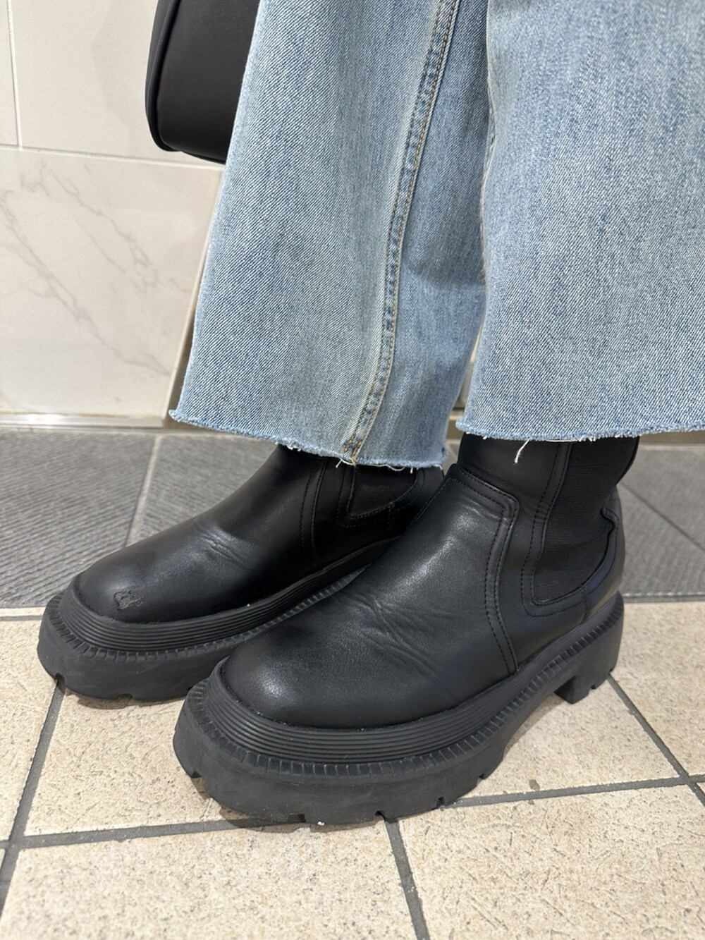 オレンジ系のカーディガン/ボレロ、ホワイト系のシャツ/ブラウス、ブルー系のデニムパンツを着用したレディースの冬コーディネートの8枚目の写真