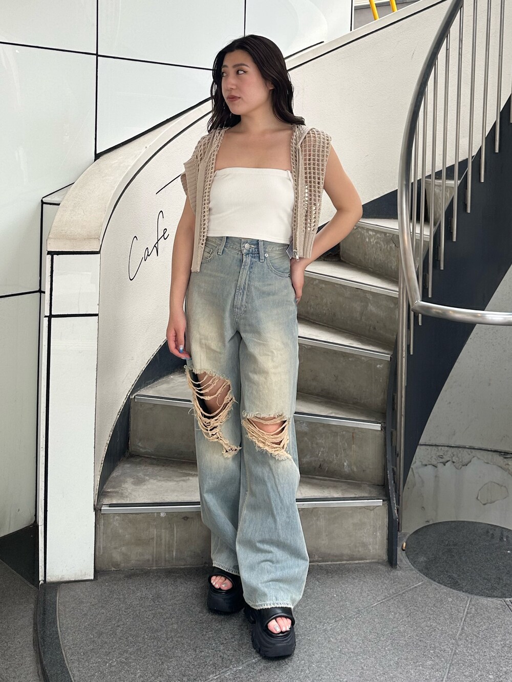 ホワイト系のニット/セーター、ブルー系のデニムパンツ、ブラック系のサンダルを着用したレディースの夏コーディネートの2枚目の写真