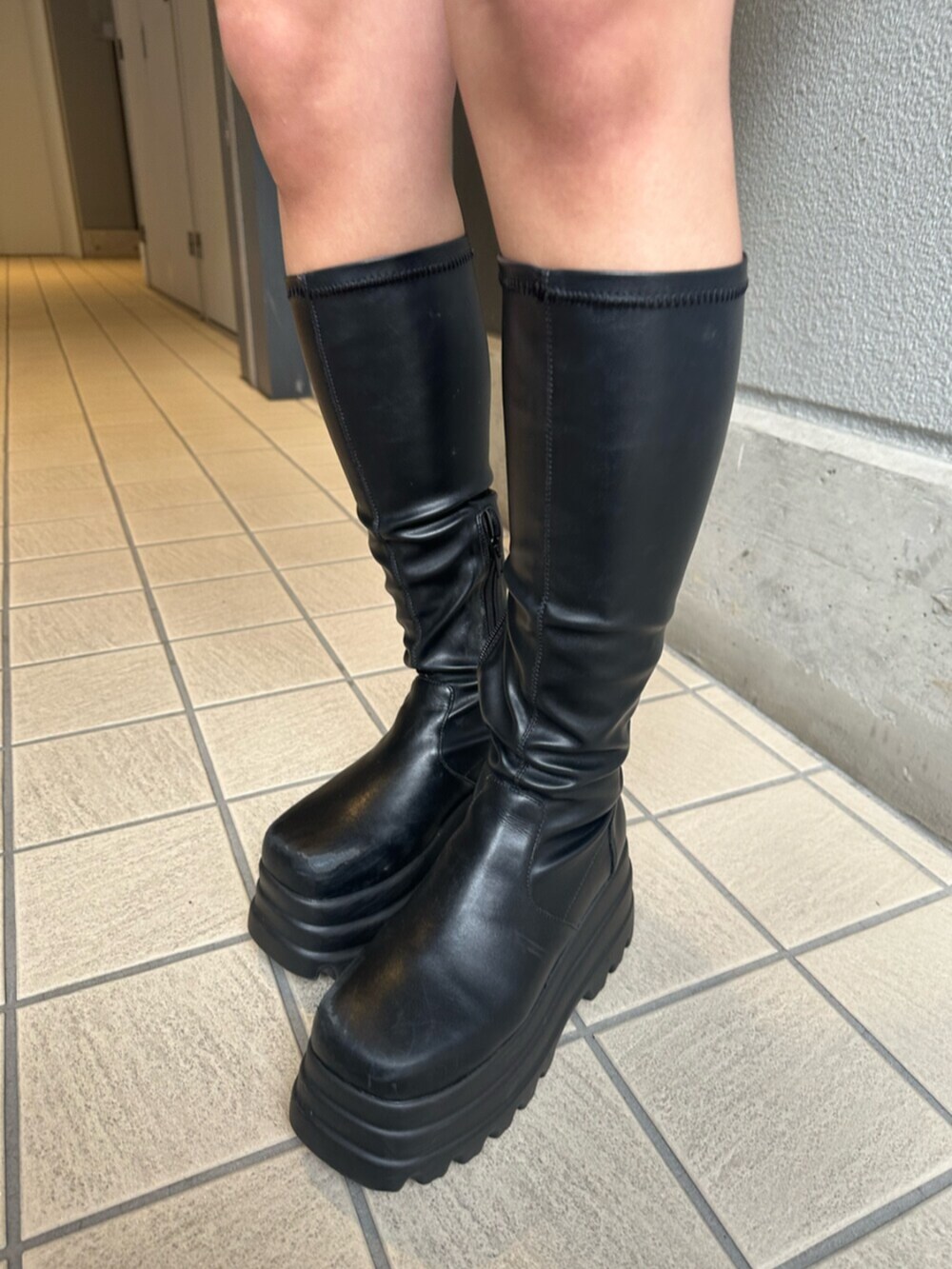 ブラック系のブーツ、ブルー系のデニムスカート、ブラック系のニット/セーターを着用したレディースの冬コーディネートの7枚目の写真