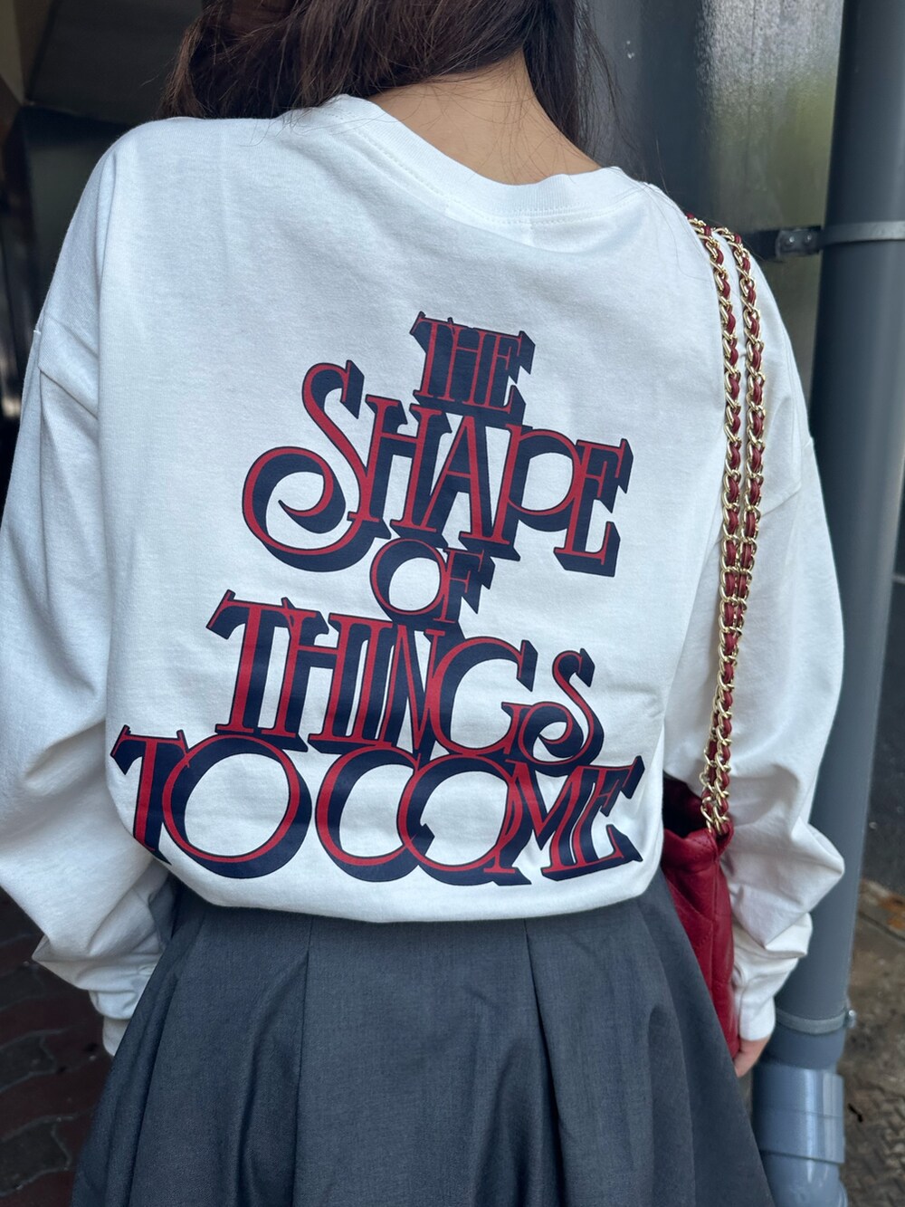 ホワイト系のTシャツ/カットソー、グレー系のスカート、ブラック系のブーツを着用したレディースの秋コーディネートの7枚目の写真